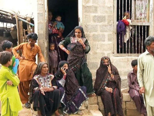 a family of fishermen from keti bandar sits outside the home of their relatives in karachi s rehri goth photo express