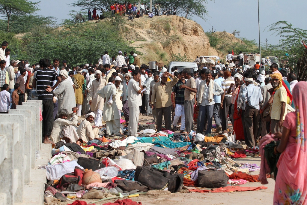 indian bystanders surround the bodies of hindu devotees crushed in a stampede on a bridge outside the ratangarh temple at datia photo afp