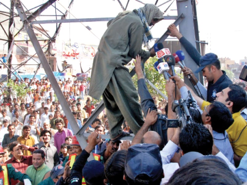 shabbir ail is swamped by police and media as he climbs down photo abid nawaz express