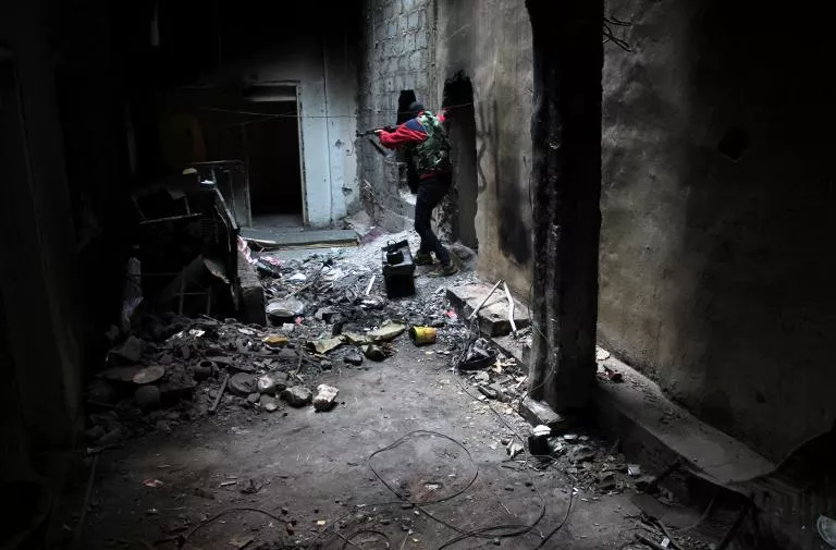 an opposition fighter patrols through an abandoned building in the jubaila neighbourhood of syria 039 s northeastern city of deir ezzor photo afp an opposition fighter patrols through an abandoned building in the jubaila neighbourhood of syria 039 s northeastern city of deir ezzor photo afp