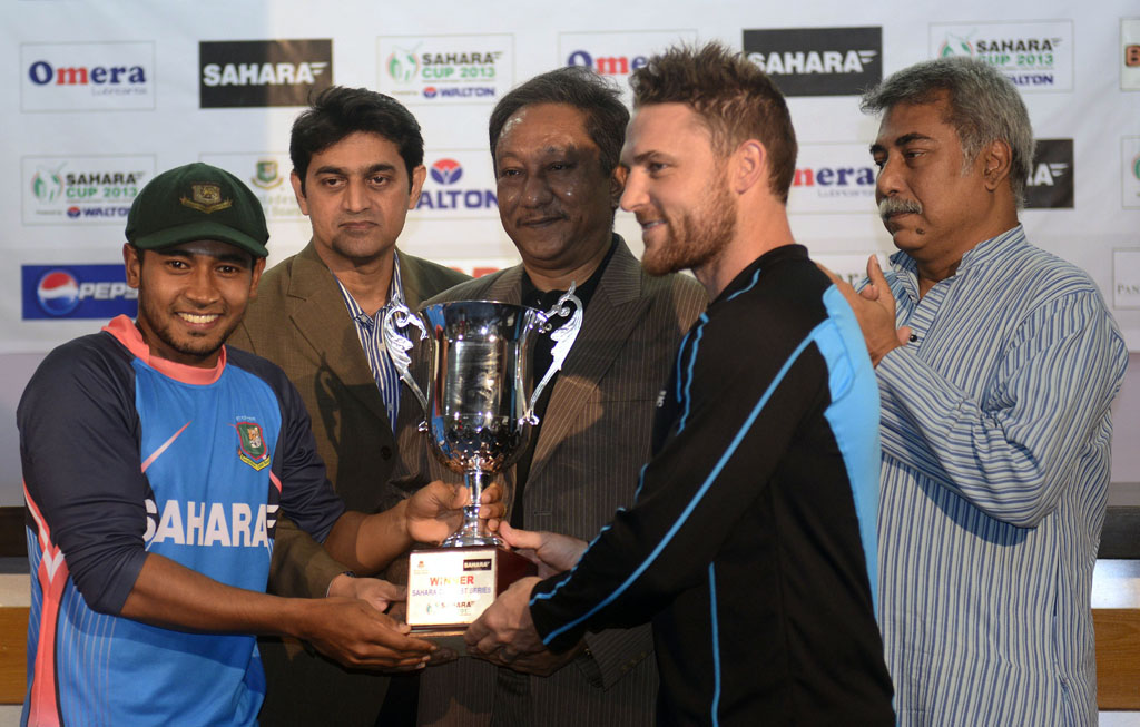 bangladesh cricket captain mushfiqur rahim l and new zealand cricket captain brendon mccullum 2nd r take the tournament trophy from bangladesh cricket board bcb president nazmul hasan papon c photo afp