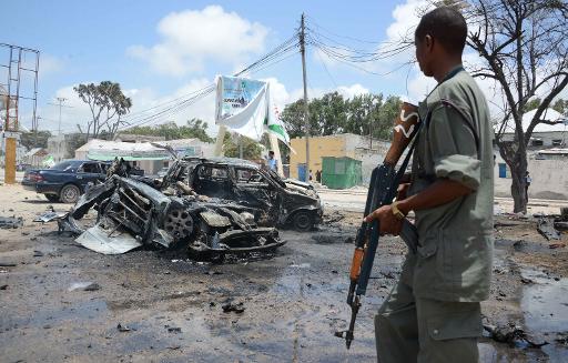 file picture shows an armed man stands guard at the scene of two explosions in mogadishu photo afp