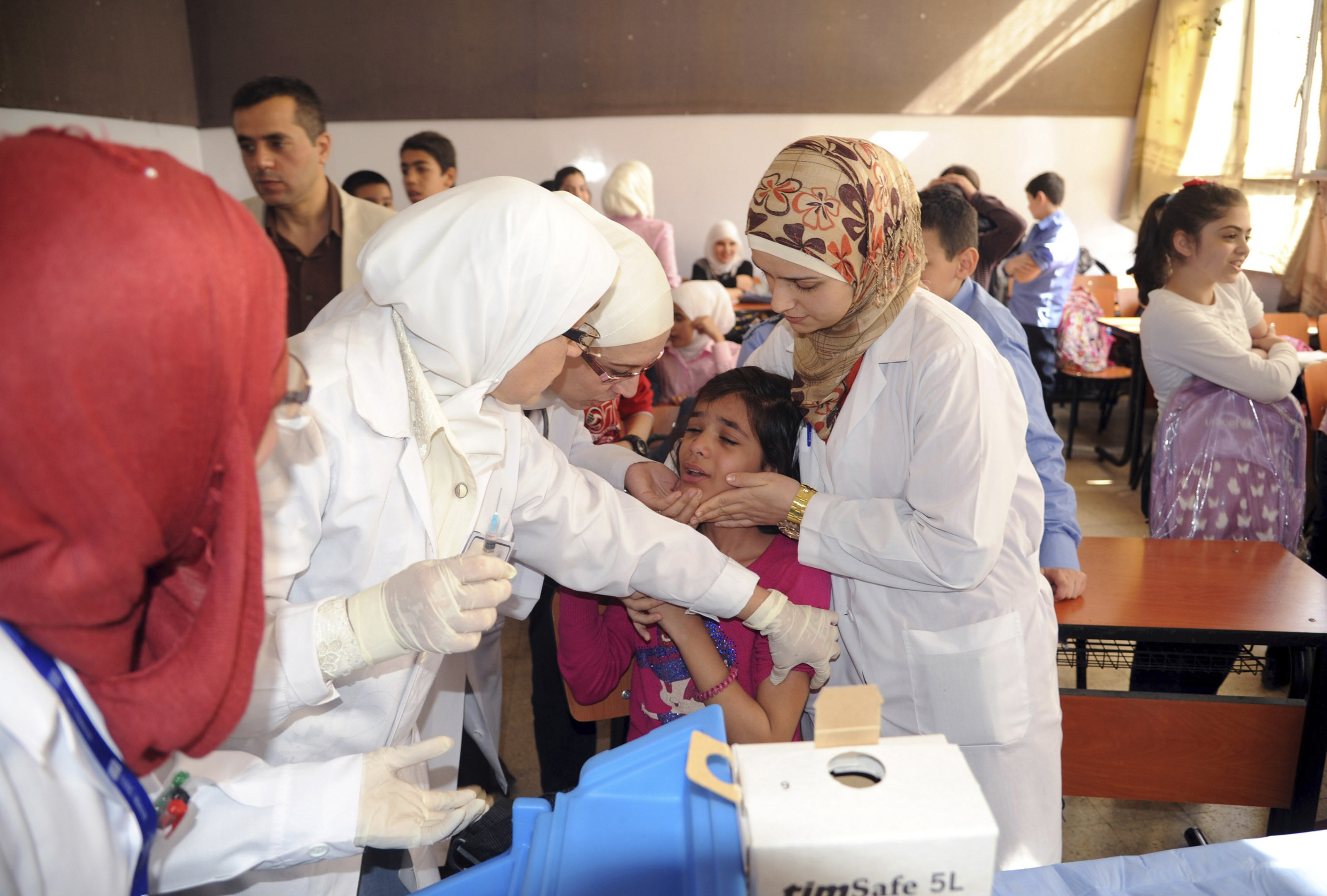 a syrian health worker administers polio vaccination to a girl at a school in damascus in this file photo taken by syria 039 s national news agency sana on october 20 2013 photo reuters