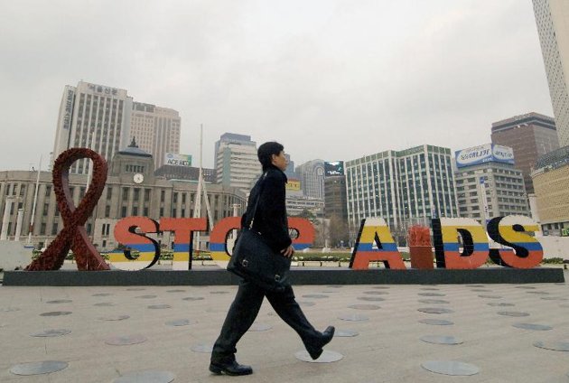 a man walks past an aids campaign board in seoul korea on december 1 2005 as part of world aids day photo afp file