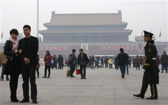 a paramilitary soldier patrols near visitors posing for souvenir pictures at tiananmen square in beijing photo reuters a paramilitary soldier patrols near visitors posing for souvenir pictures at tiananmen square in beijing photo reuters