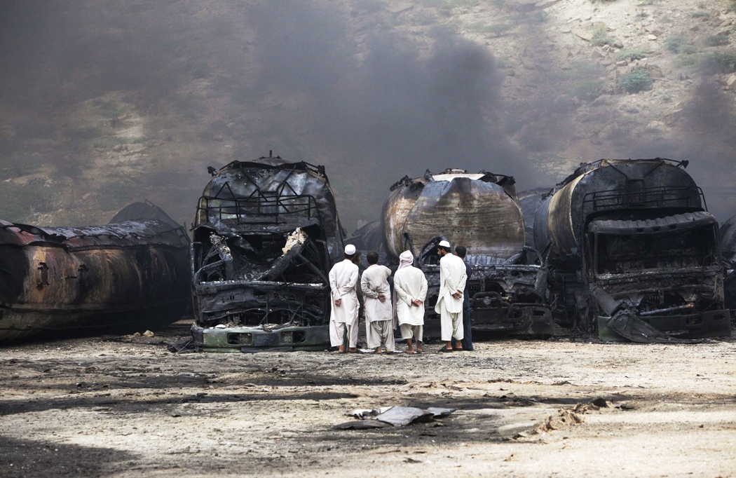 men stand near damaged tankers of a nato supply convoy after an attack a day earlier in hub about 25 km from karachi september 16 2013 photo reuters