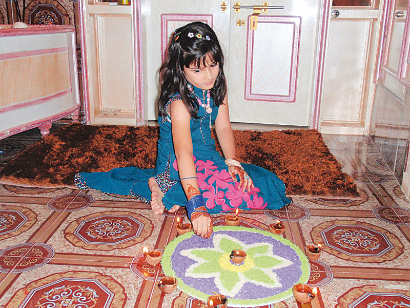 advocate mukesh kumar karara and his family spent a joyful diwali day on sunday his daughter heer prepared the rangoli left with the help of her sisters right the swami narayan temple in karachi was quite deserted this year as most families chose to pray at home photos express