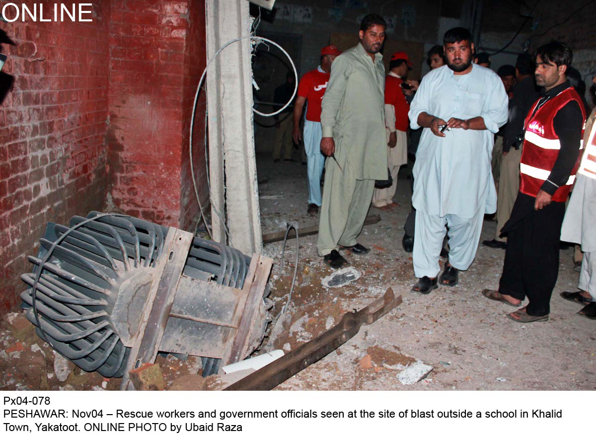 rescue workers and government officials seen near the site of a bomb blast in peshawar on monday photo online