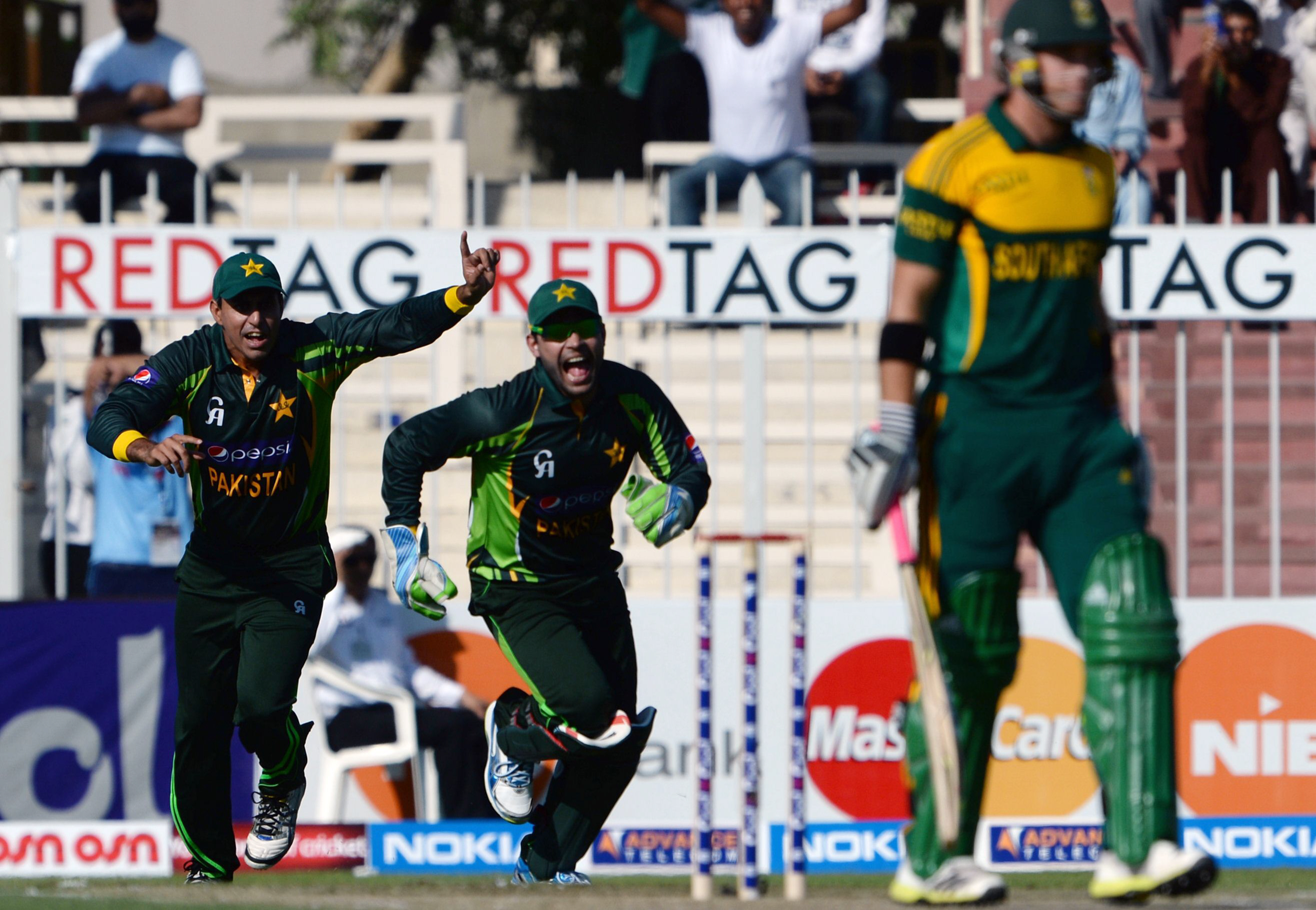 pakistan 039 s wicket keeper umar akmal c celebrates after taking a catch of south african player ca ingram r during the first one day in sharjah cricket stadium in sharjah on october 30 2013 photo afp