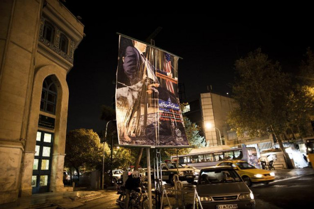 an anti american poster depicting an american negotiator sitting at a negotiating table with a dog on his side is displayed next to a mosque in downtown tehran on october 27 2013 photo afp an anti american poster depicting an american negotiator sitting at a negotiating table with a dog on his side is displayed next to a mosque in downtown tehran on october 27 2013 photo afp