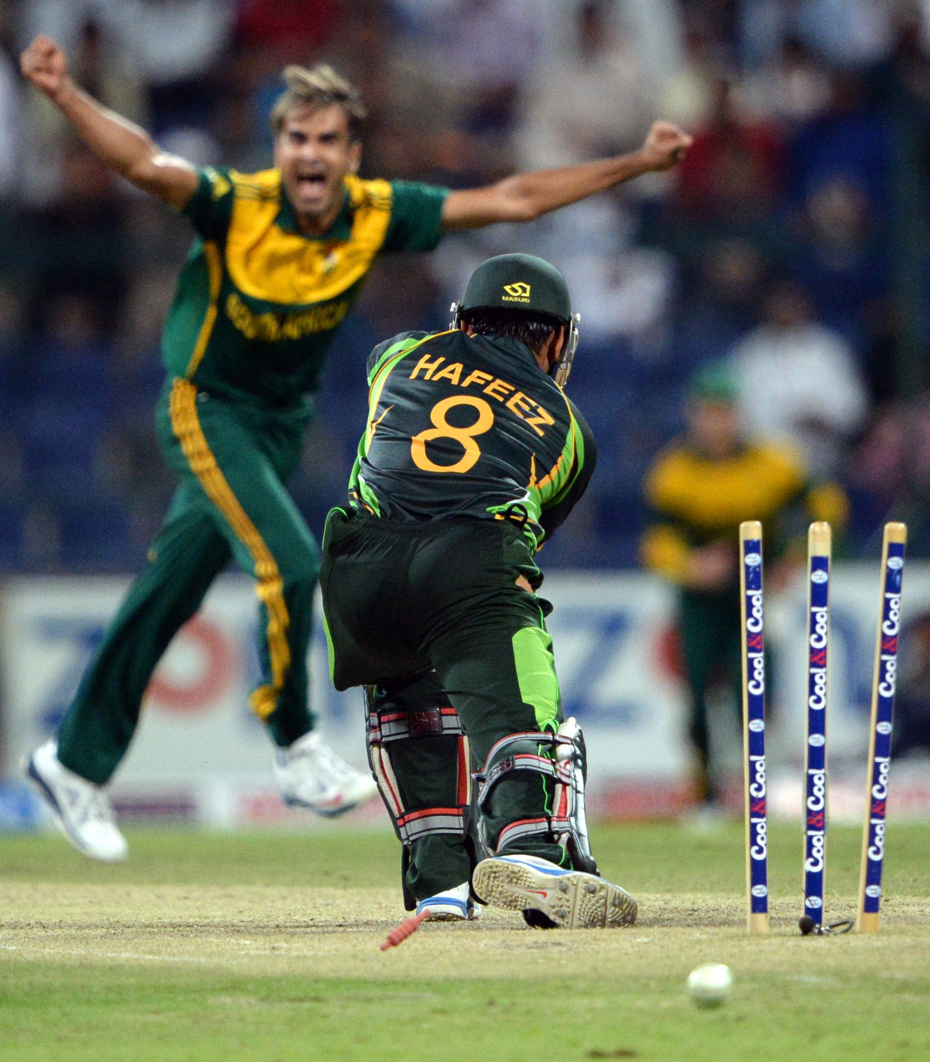 pakistan 039 s batsman mohammad hafeez r is clean bowled by south african bowler imran tahir l during the fourth day night international in sheikh zayed cricket stadium in abu dhabi on november 8 2013 photo afp