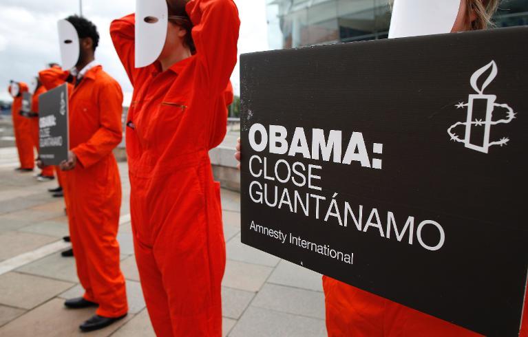 amnesty international supporters call on president obama to close the guantanamo bay military detention camp during a protest in belfast northern island on june 16 2013 photo afp