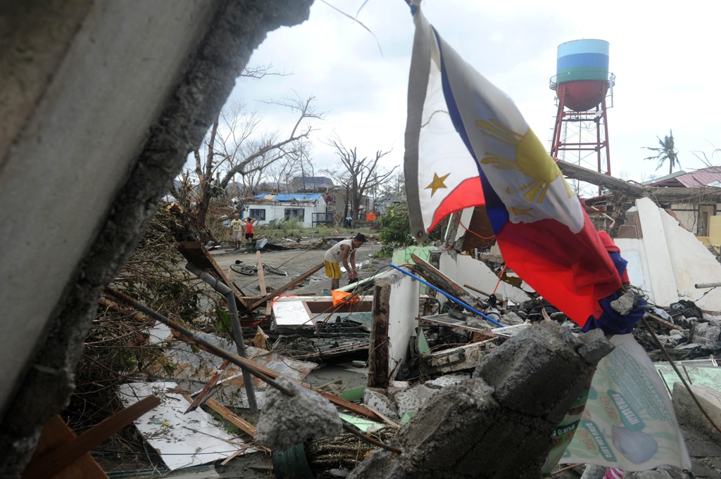 a man searches for salvageable materials among debris of his destroyed house near tacloban airport eastern island of leyte on november 9 2013 photo afp