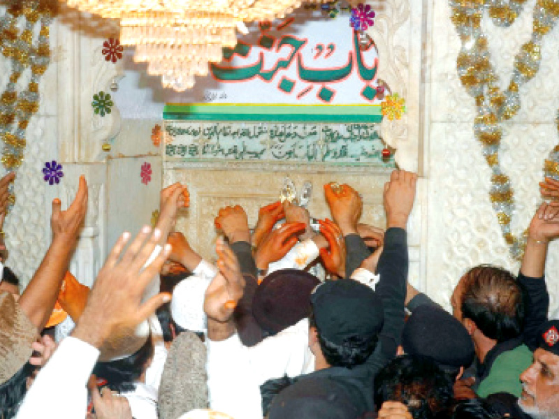 devotees wait as the shrine caretaker opens the bahishti darwaza on the night of the 6th of muharram photo express