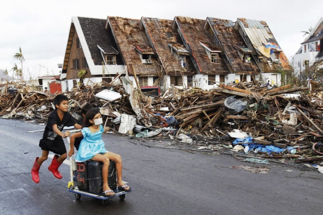 residents pass houses devastated by typhoon haiyan in tacloban city central philippines november 13 2013 photo reuters residents pass houses devastated by typhoon haiyan in tacloban city central philippines november 13 2013 photo reuters