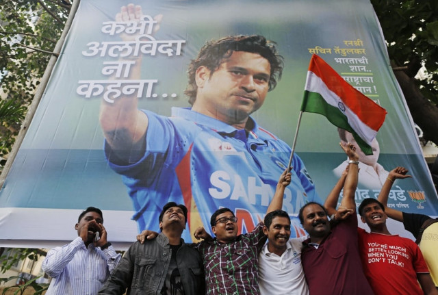 cricket fans holding an indian national flag shout slogans in front of a billboard of cricketer sachin tendulkar outside a stadium in mumbai november 14 2013 photo reuters