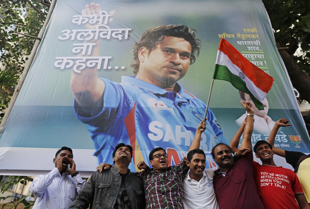 cricket fans holding an indian national flag shout slogans in front of a billboard of cricketer sachin tendulkar outside a stadium in mumbai november 14 2013 photo reuters