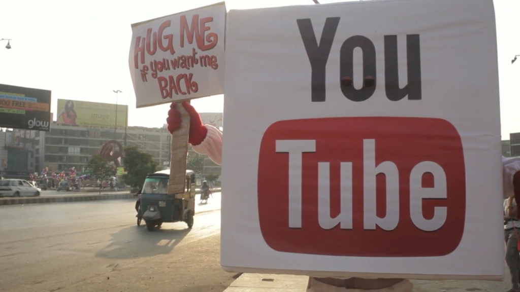 screengrab of the youtube mascot holding a sign that reads quot hug me if you want me back quot