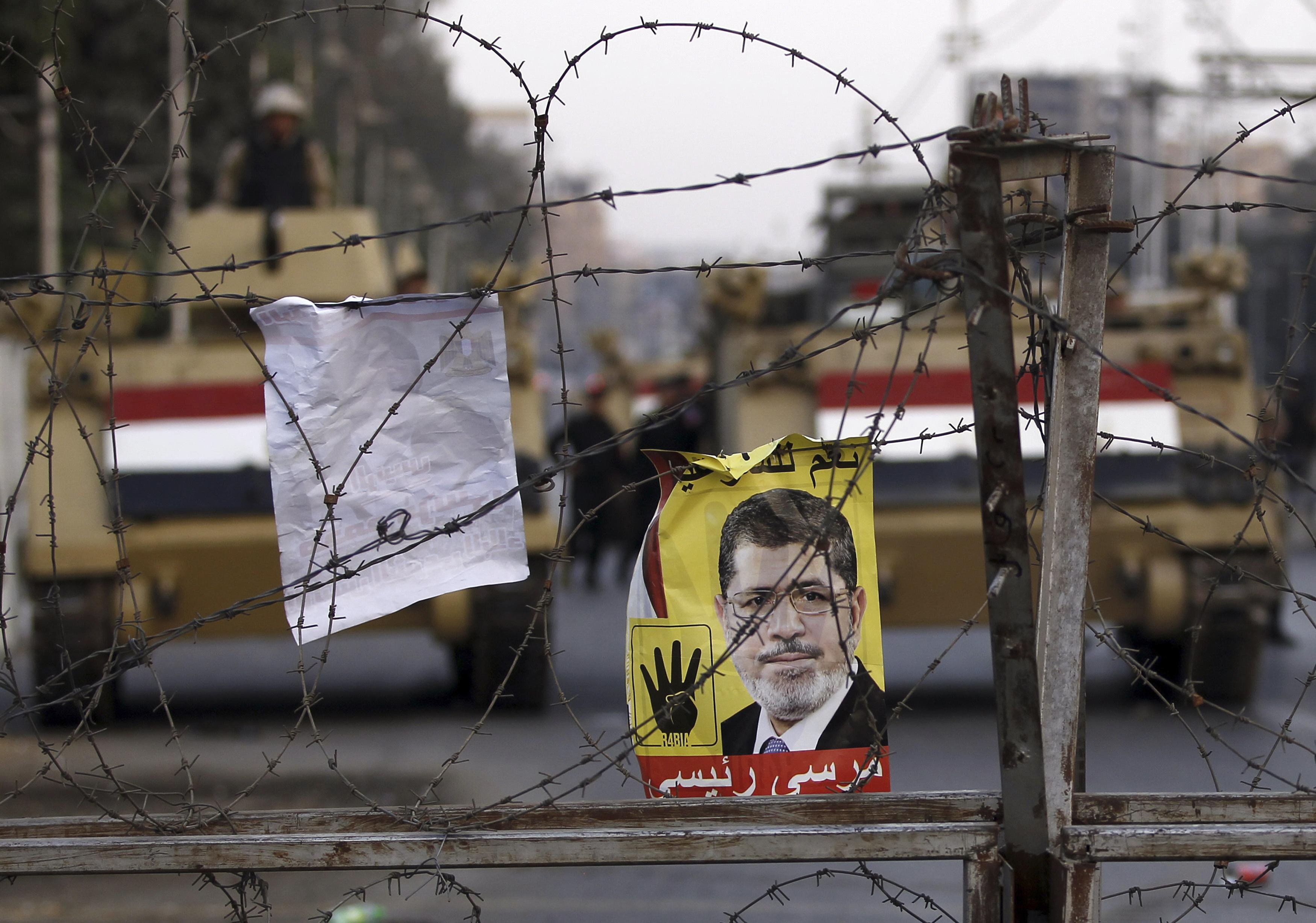 a poster of ousted egyptian president mohamed mursi is pictured on barbed wires during a protest by his supporters at el thadiya presidential palace in cairo november 15 2013 photo reuters