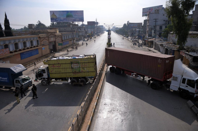 security personnel keep watch near trucks used to block a street during a curfew following sectarian clashes in rawalpindi on november 16 2013 photo afp security personnel keep watch near trucks used to block a street during a curfew following sectarian clashes in rawalpindi on november 16 2013 photo afp