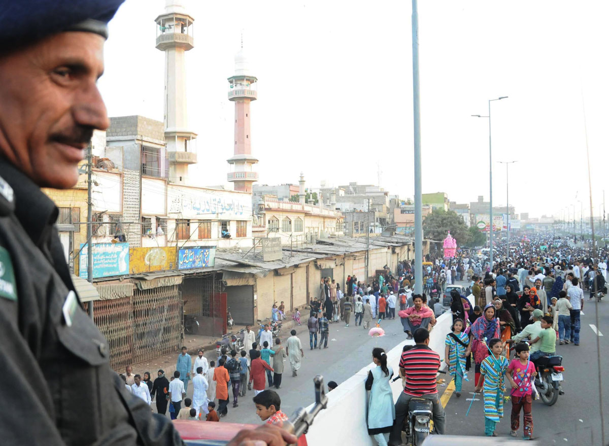 a policeman stands guard as an ashura procession passes through liaquatabad area of karachi photo mohammad saqib express