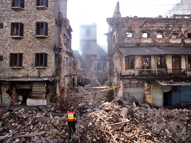 a rescue worker makes his way through buildings damaged during the ashura violence photo muhammad javaid express