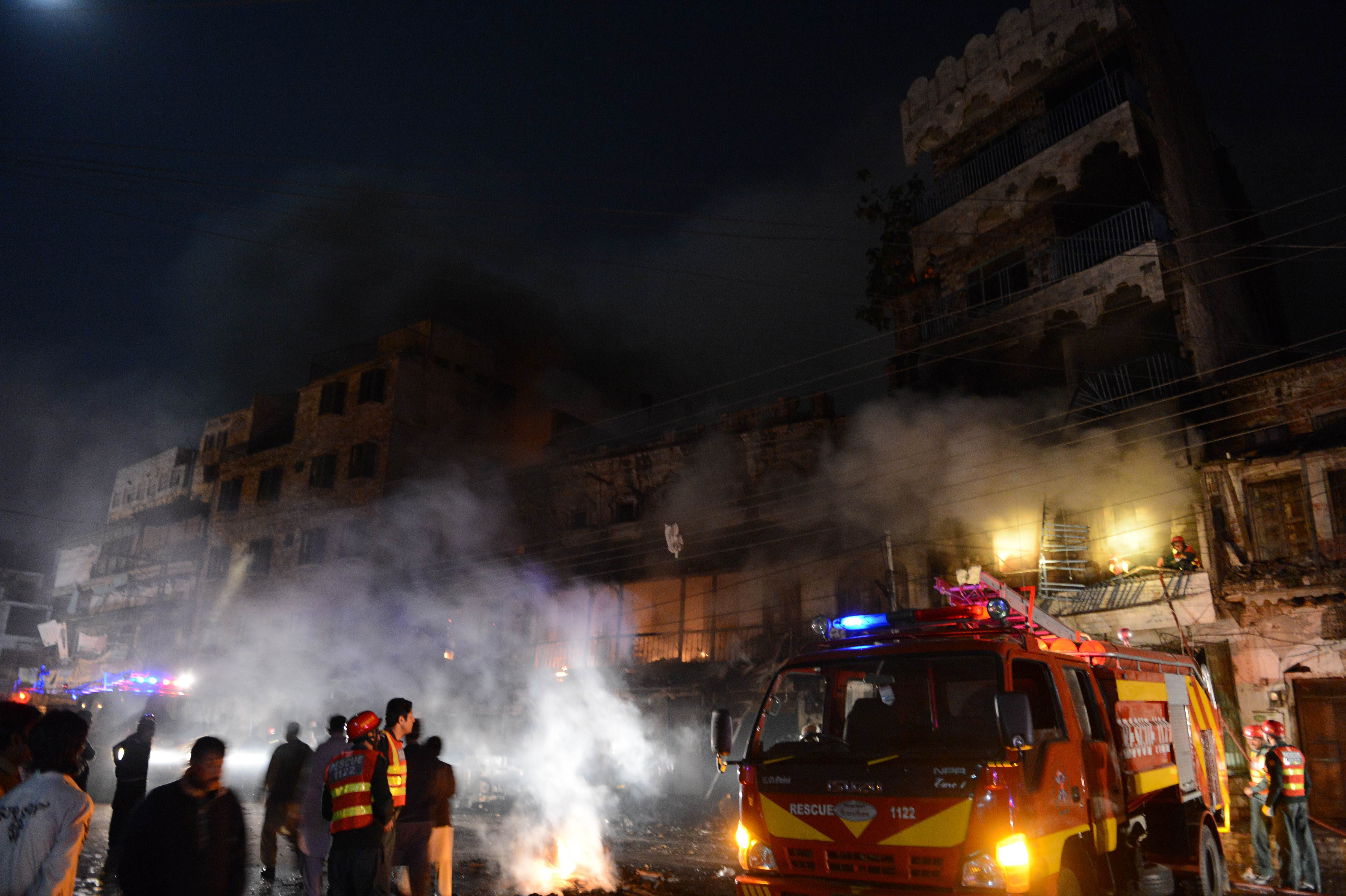 pakistani rescuers and security personnel gather in front of a burning market after sectarian clashes near a mosque during the shia procession in rawalpindi on november 15 2013 photo afp