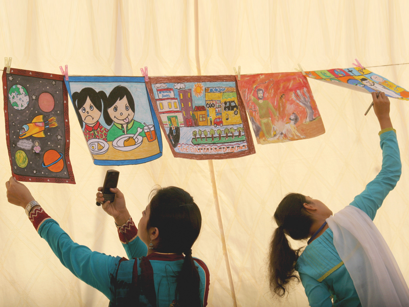 schoolchildren look at the paintings of five shortlisted candidates of different schools at a programme hosted by ngo aahung to celebrate universal children s day on wednesday photo athar khan express