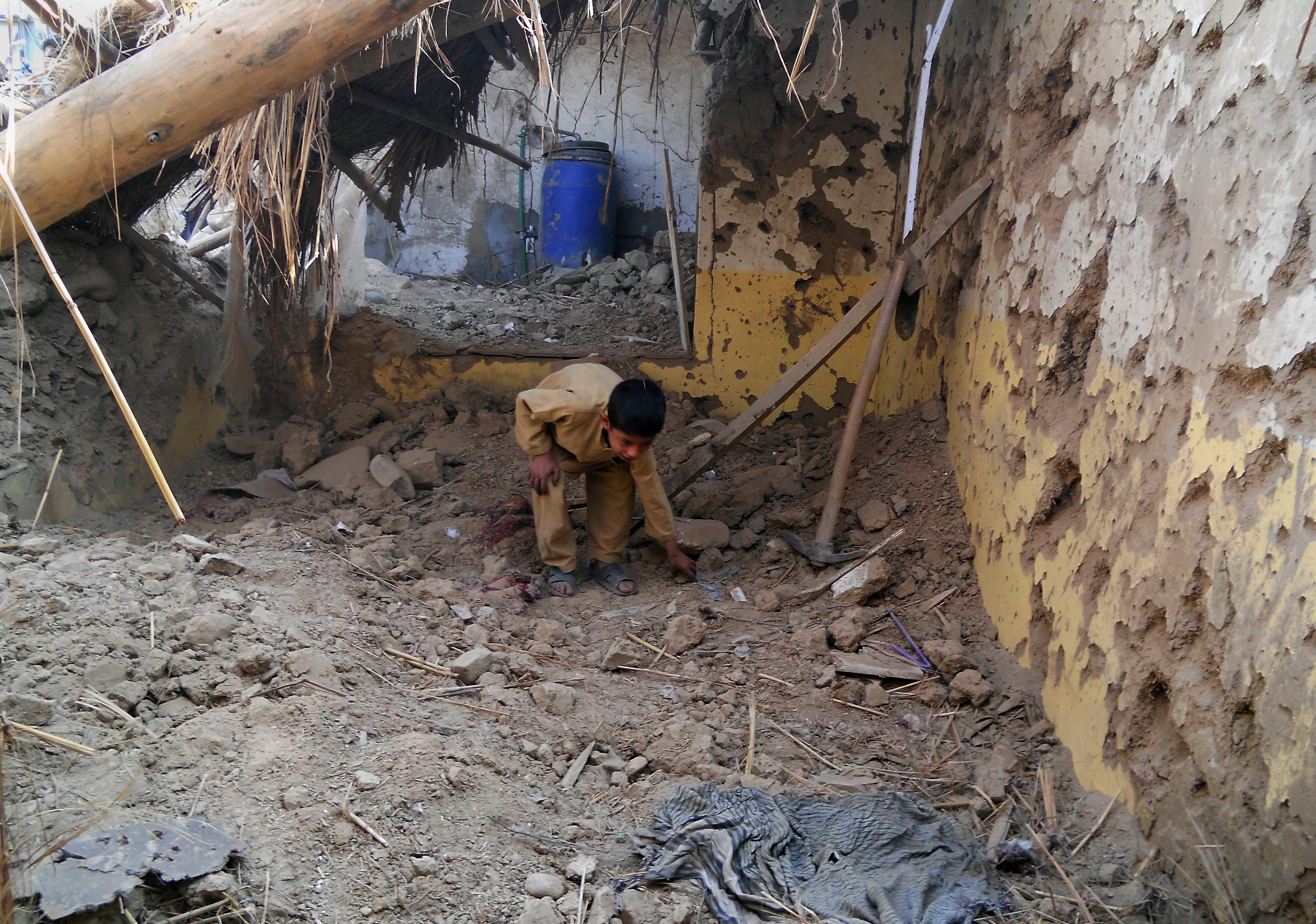a child sifts through rubble at a destroyed seminary after a drone strike in hangu photo afp