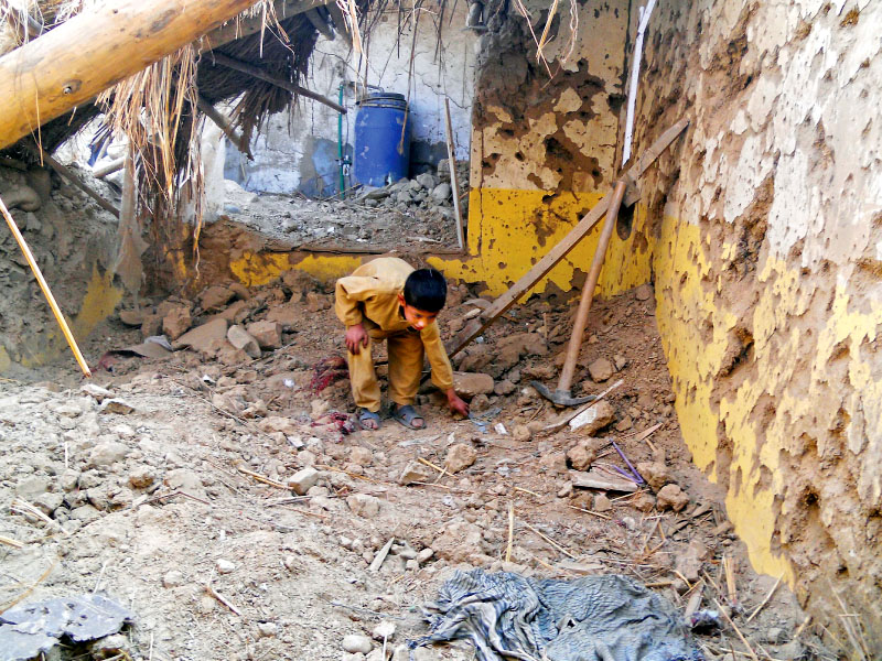 a child sifts through rubble at the seminary destroyed in the drone strike in hangu photo afp