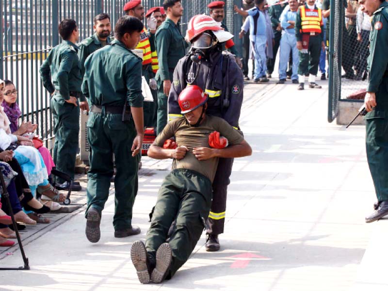 a rescuer evacuates his colleague from a bomb site in an exercise on friday photo shafiq malik express