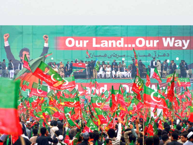 pti activists wave party flags during the rally on ring road where thousands of people showed up to protest drone strikes and to demand halting of nato supplies photo afp