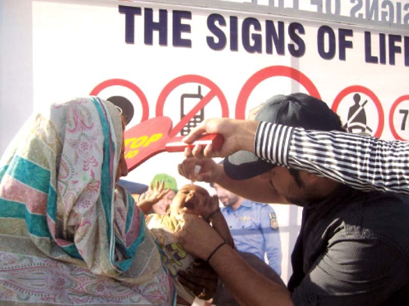 polio workers administering drops to a baby photo sehrish wasif express