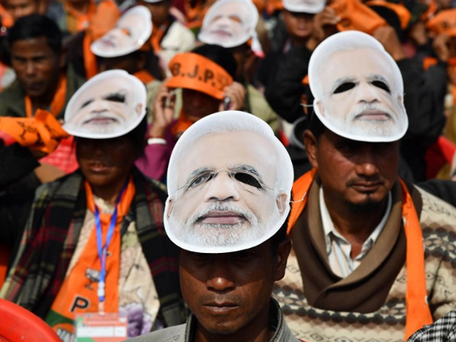 supporters of the bharatiya janata party bjp wearing masks of indian prime minister narendra modi listen to modi during a public rally in shillong on december 16 2017 photo afp