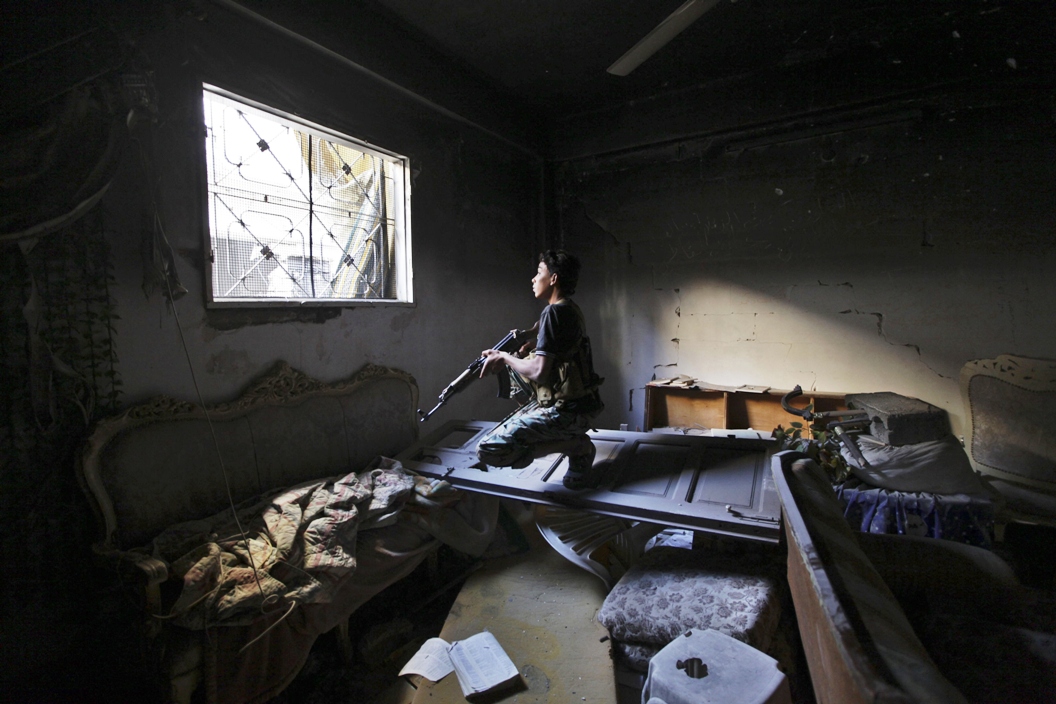 file photo of a free syrian army fighter carries his weapon in a damaged building in eastern syria photo reuters