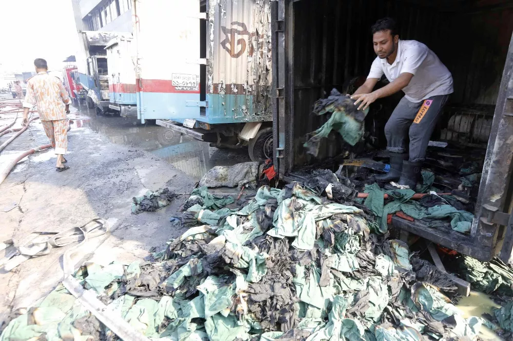 an employee unloads piles of damaged clothes from a van which was set on fire by protesting workers at a standard group garment factory in gazipur november 29 2013 photo reuters an employee unloads piles of damaged clothes from a van which was set on fire by protesting workers at a standard group garment factory in gazipur november 29 2013 photo reuters
