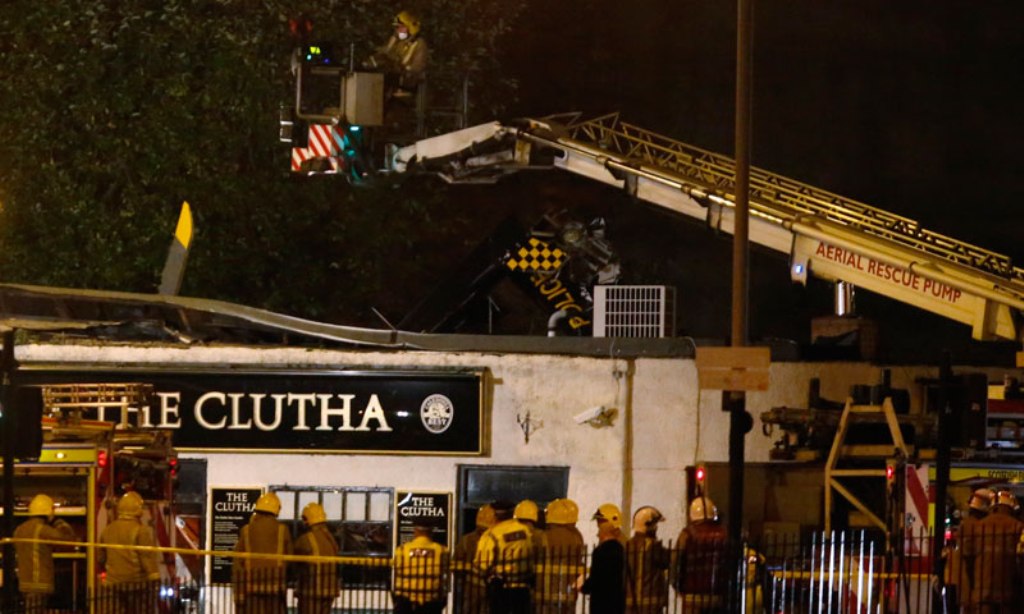 rescue workers examine the wreckage of a police helicopter which crashed onto the roof of the clutha vaults pub in glasgow scotland november 30 2013 photo reuters