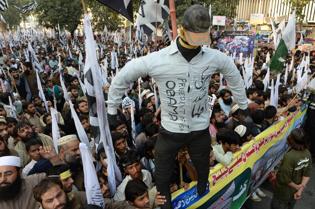 pakistani supporters of the defence of pakistan coalition shout slogans as they hold up an effigy of us president barack obama at an anti us rally in lahore on december 1 2013 photo afp