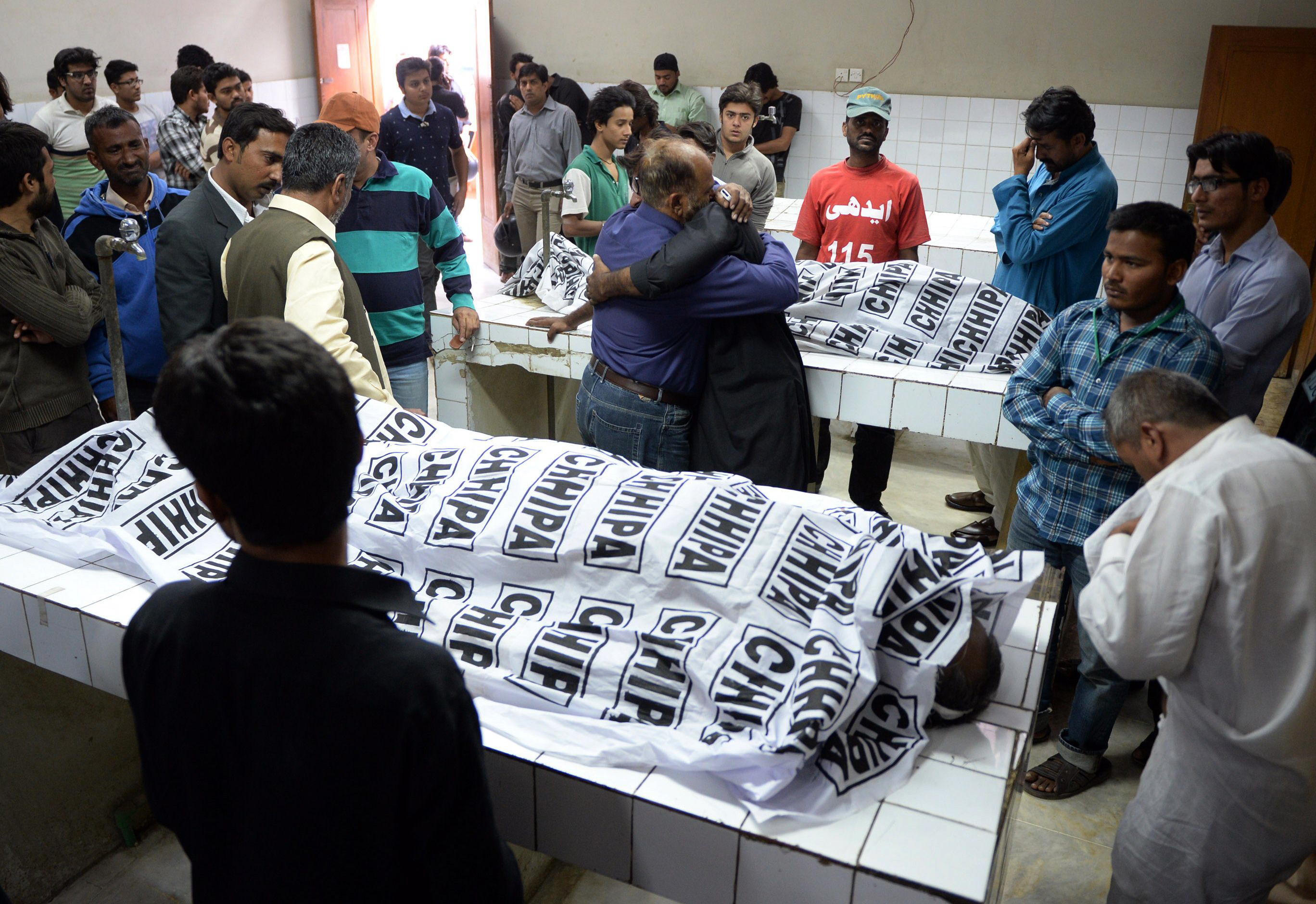 pakistani mourners gather around the bodies of the mwm leader and his guard at a mortuary photo afp