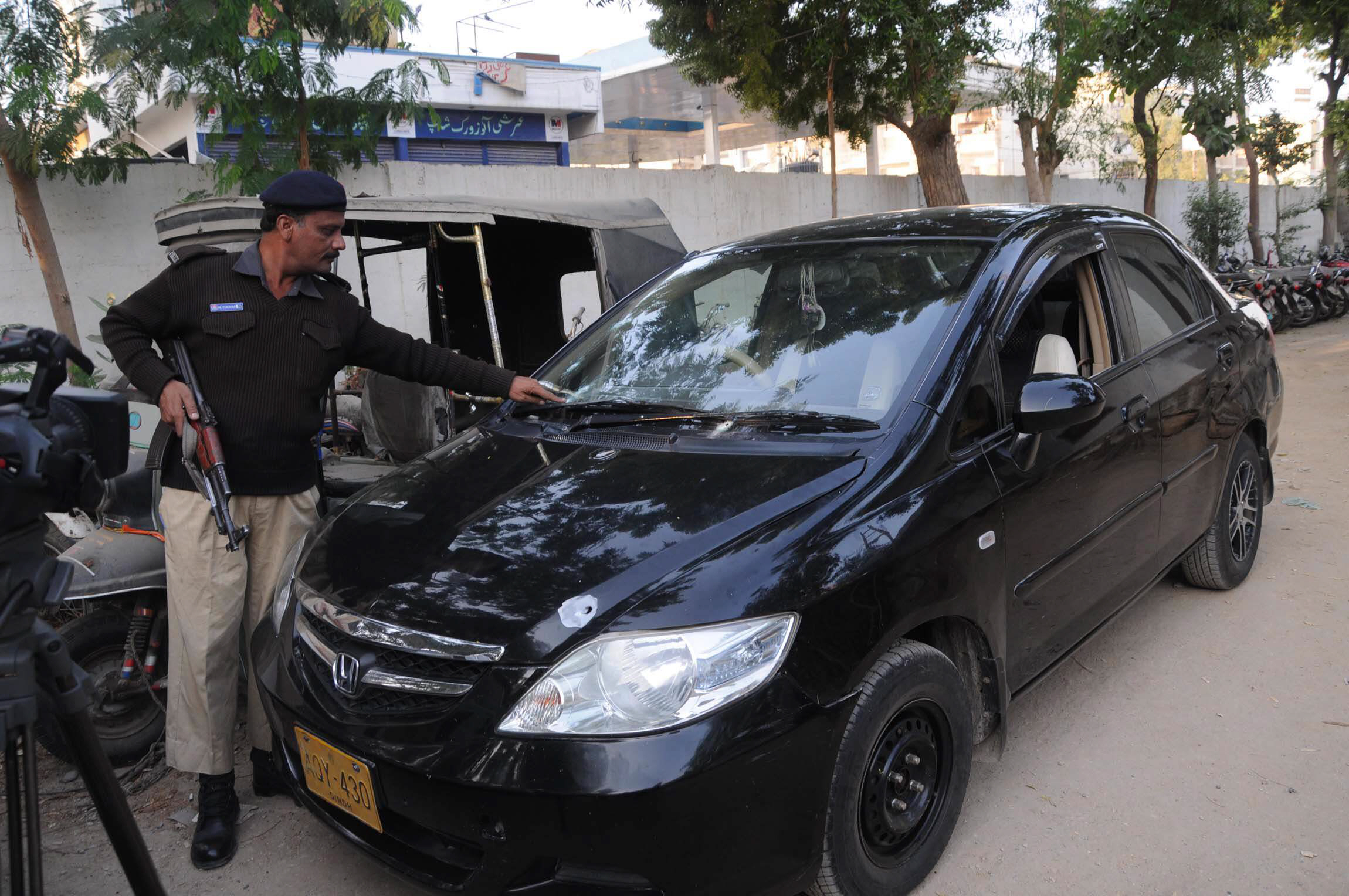 a police official looks at the car of slain mqm leader photo mohammad noman express