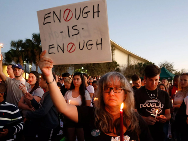 mourners stand during a candlelight vigil for the victims of marjory stoneman douglas high school shooting in parkland florida on february 15 2018 photo afp
