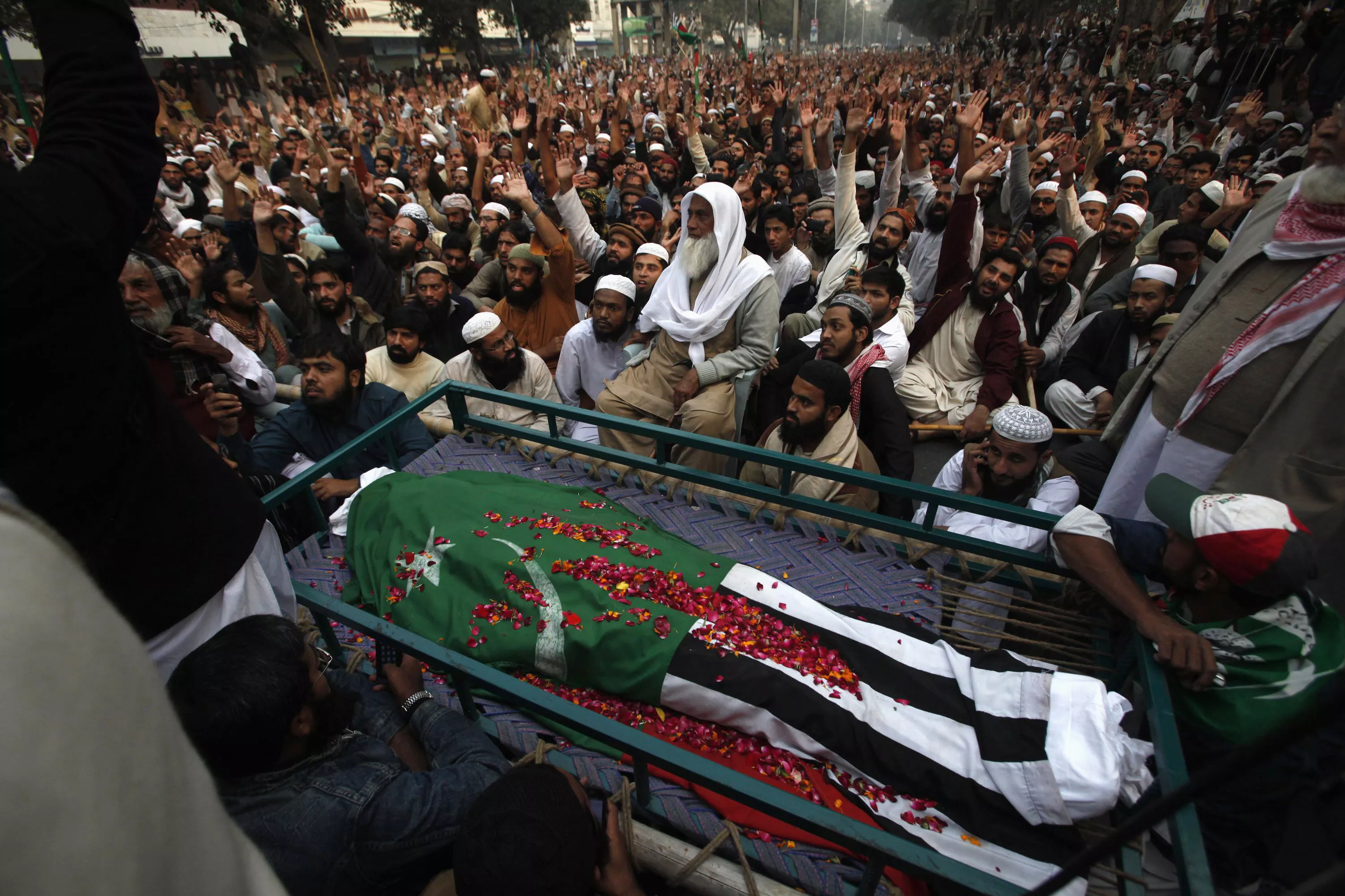 supporters of ahl i sunnat wal jamaat aswj sit near the body of their party leader maulana shamsur rehman wrapped in the party 039 s flag while shouting slogans during a funeral procession in lahore december 7 2013 photo reuters supporters of ahl i sunnat wal jamaat aswj sit near the body of their party leader maulana shamsur rehman wrapped in the party 039 s flag while shouting slogans during a funeral procession in lahore december 7 2013 photo reuters