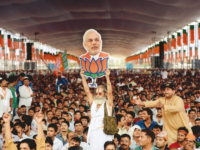 a bjp supporter holds a cutout of narendra modi after the party s state election victory photo afp