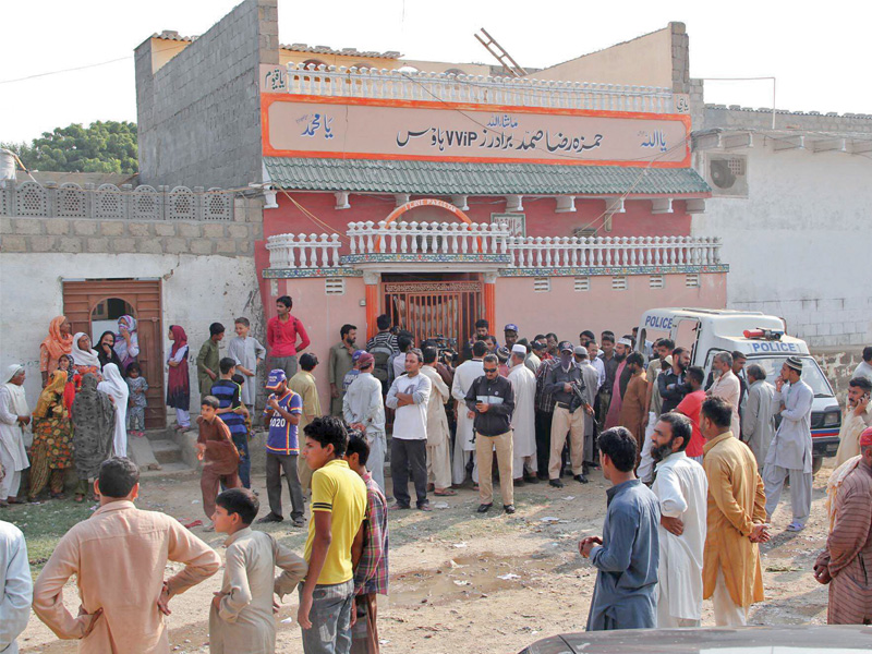 neighbours and law enforcers gather outside the house of the family in baldia town who were found dead from mysterious causes on monday morning photo mohammad azeem express