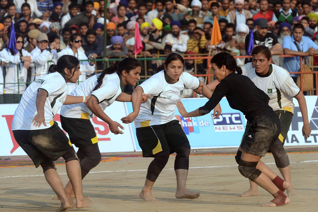 a danish kabaddi player top tackles her pakistani opponent during the 4th world cup kabaddi punjab 2013 tournament at a stadium in chohla sahib tarn taran about 55 kms from amritsar on december 2 2013 photo afp