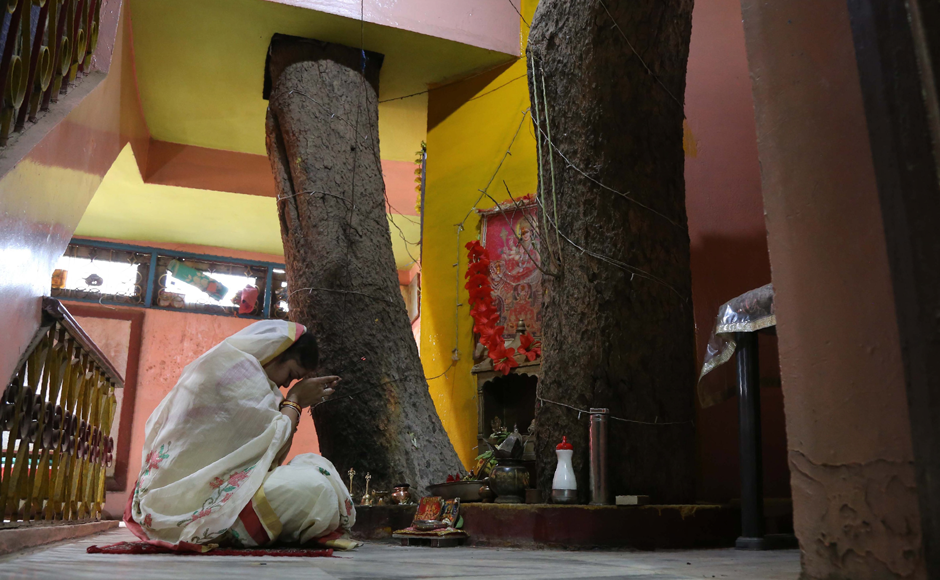 Neelu Kesharwani, daughter-in-law of Moti Lal Kesharwani who built the house around a peepal tree (sacred fig tree), performs a ritual next to the tree on the second floor of their house in Jabalpur, in the Indian state of Madhya Pradesh. Photo: Reuters