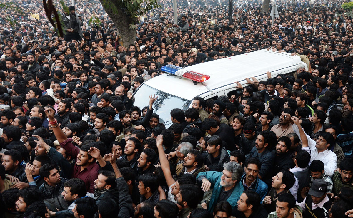 mourners surround an ambulance carrying the body of shia scholar allama nasir abbas in lahore on december 16 2013 photo afp