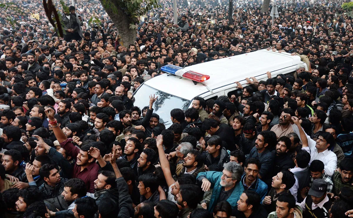 mourners surround an ambulance carrying the body of shia scholar allama nasir abbas in lahore on december 16 2013 photo afp mourners surround an ambulance carrying the body of shia scholar allama nasir abbas in lahore on december 16 2013 photo afp