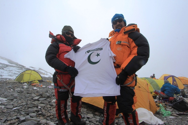 samina baig and mirza ali holding up their favourite shirt while scaling a mountain photo mirzaadventure blogspot com