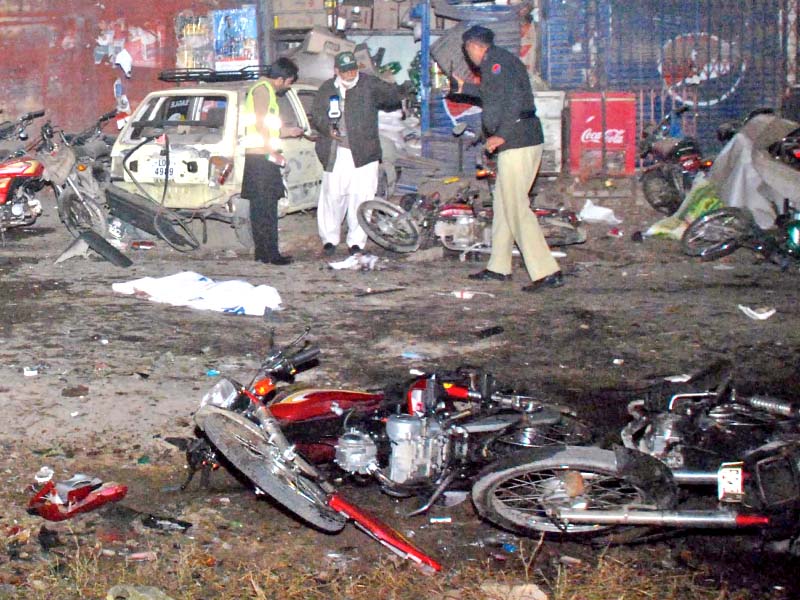 policemen inspects the site of the suicide blast outside an imambargah photo muhammad javaid express